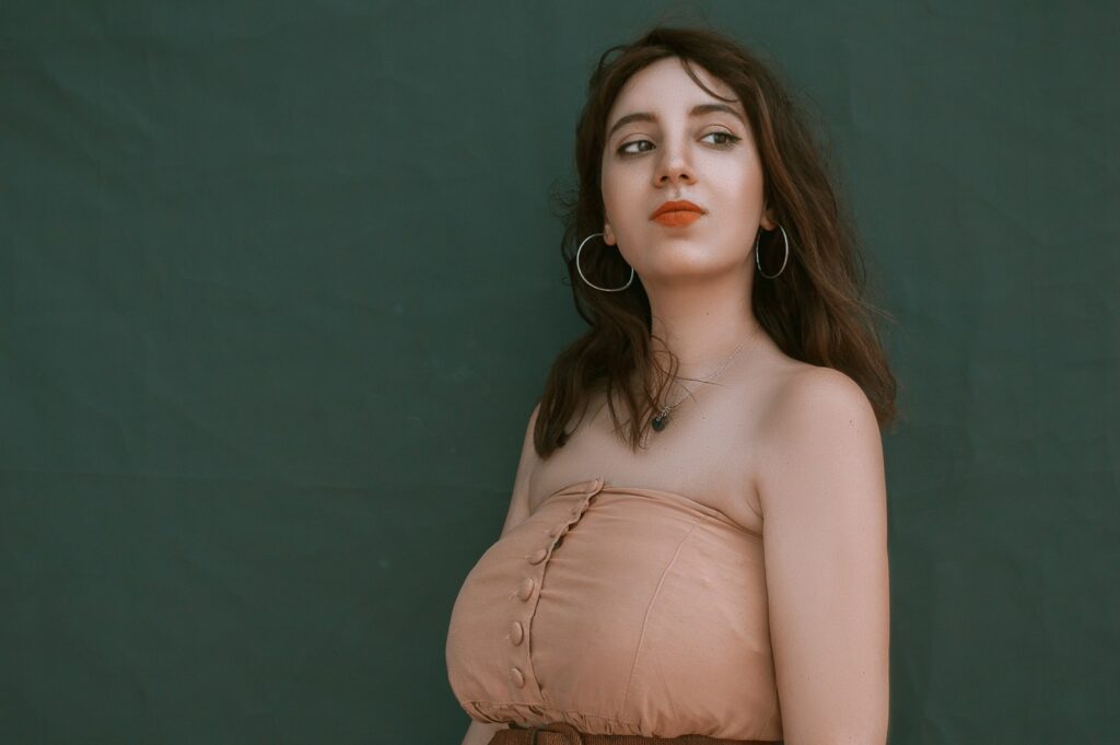 woman in brown top beside wall