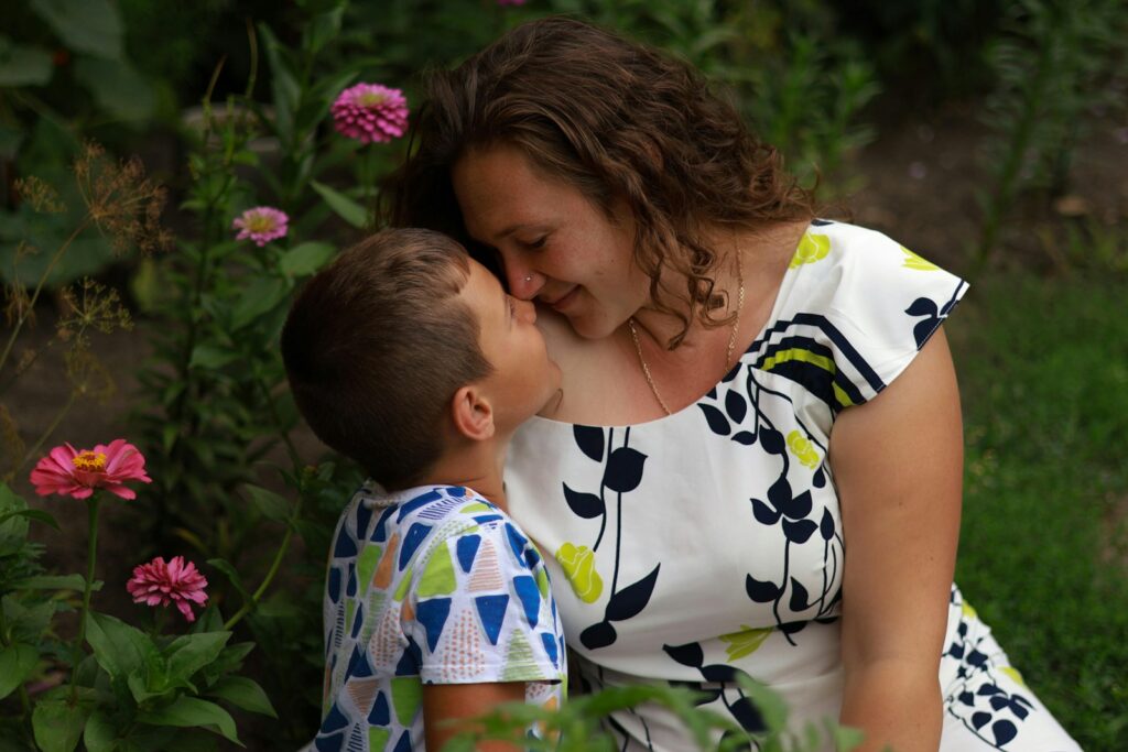 a woman kissing a boy in a field of flowers